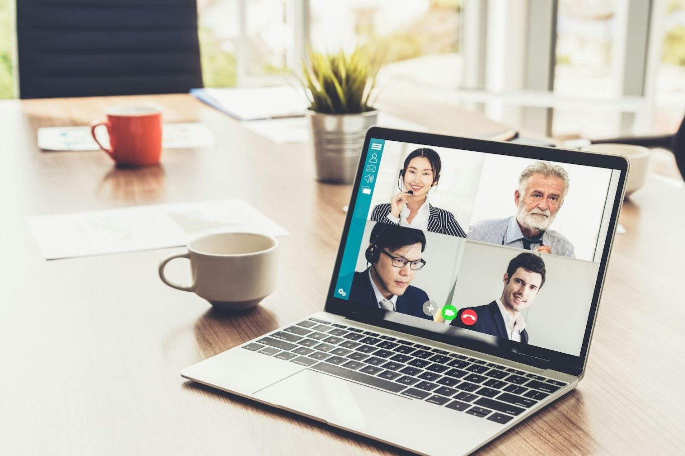 virtuelles Konfliktmanagement Videokonferenz mit mehreren Teilnehmern auf einem Laptop in einem modernen Büro.