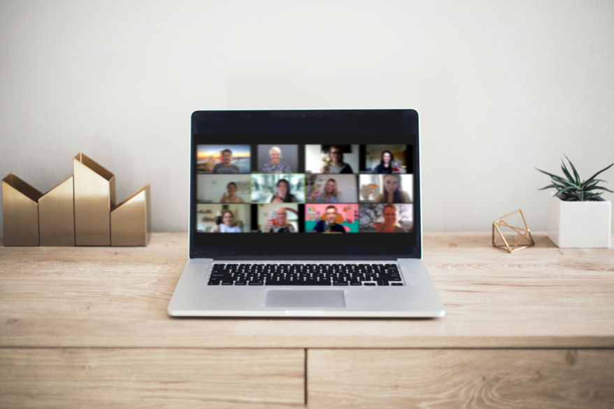 online Mediation Laptop auf einem Tisch, zeigt eine Videokonferenz mit mehreren Teilnehmern.